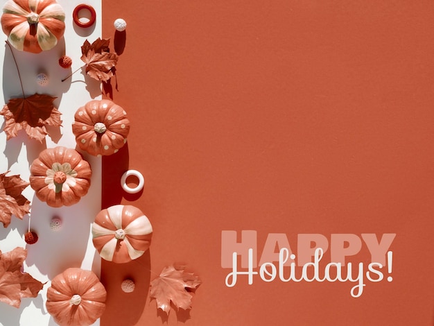 Bordo decorativo con decorazioni autunnali rosse aspetto monocromatico con zucche beige dipinte e foglie autunnali secche testo piatto happy holidays