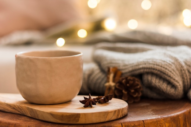 Decorative ceramic cup on wooden hot pad