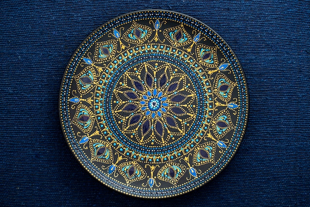 Decorative ceramic plate with black, blue and golden colors