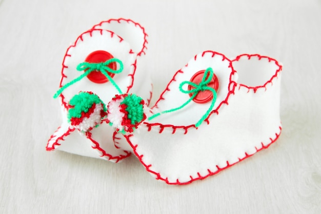 Decorative Christmas shoes on wooden surface