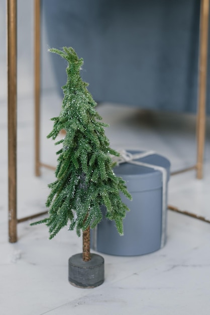 Decorative christmas tree and round gift box in the interior of\
a cozy holiday home