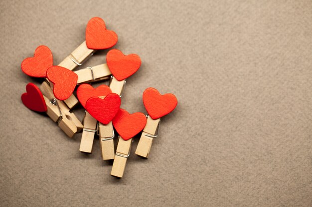 Decorative clothespins with heart on brown surface