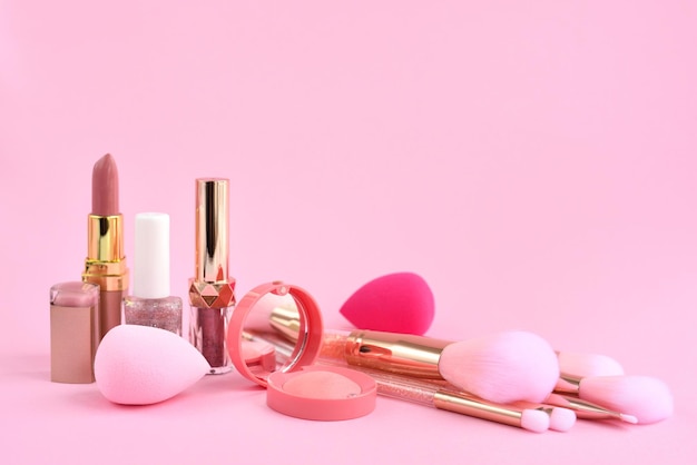照片装饰化妆品海绵和化妆刷上粉红色的背景