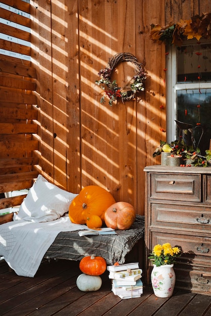 Decorative design window on the terrace autumn wreath and pumpkins vintage old chest drawers wooden rustic background