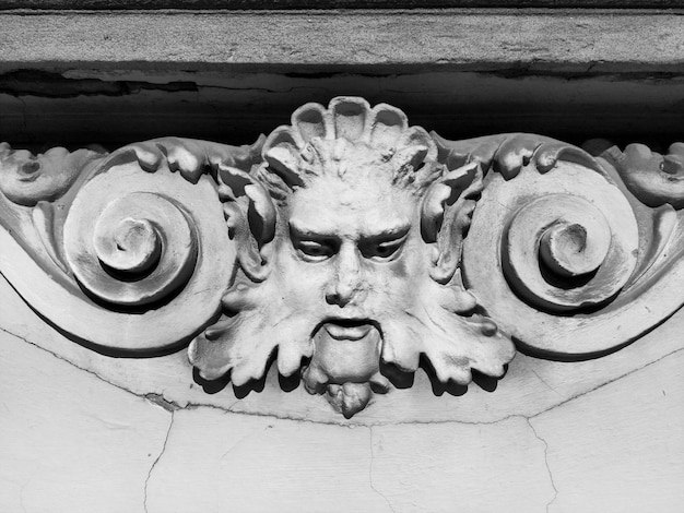 Decorative detail on the facade Relief on the facade of a building Stucco molding in the form of a man's head with curly hair mustache and curls on the sides High relief concrete basrelief