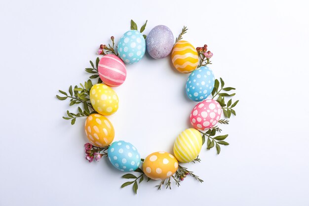 Decorative Easter eggs and flowers on white background