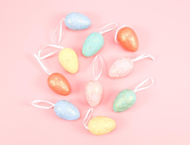 Decorative Easter marble eggs of delicate pastel colors lie in the middle on a pink