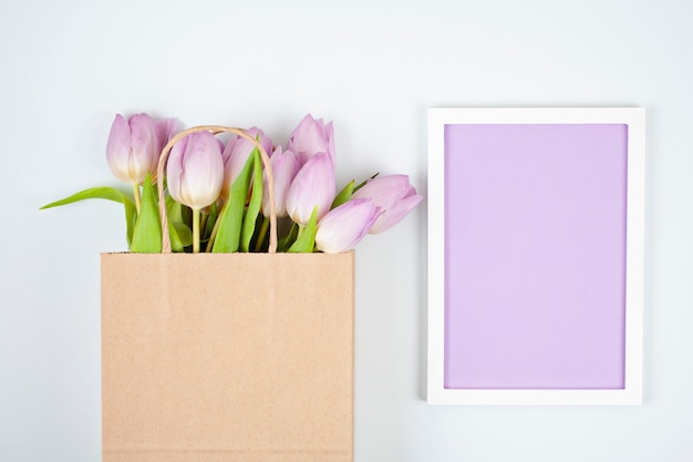 Decorative empty frame with copy space and bouquet of tulips