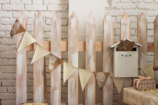 Photo decorative fence with a garland of flags and a mailbox