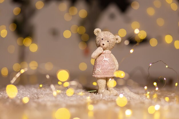 Decorative figurines of a Christmas theme. Figurine of a cute teddy bear girl in a sweater with deers. 