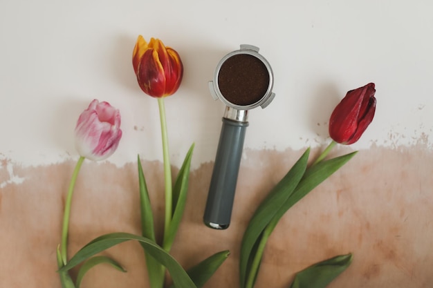 コーヒー豆と花のトップ ビューで装飾的なフラット レイアウト構成春カフェ コンセプト飲み物とコーヒーのコンセプトを作る