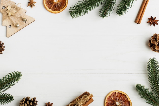 Decorative frame, christmas attributes on a white wooden table.