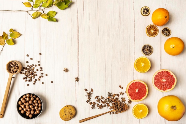 Decorative frame with citrus fruits chocolate cookies chocolates and coffee on light wooden table