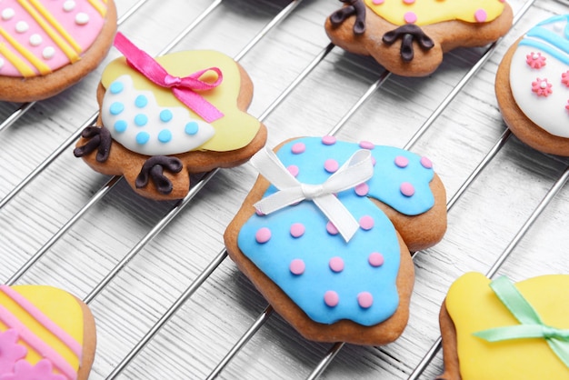 Decorative gingerbread Easter cookies on baking wire rack and white wooden background