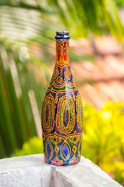 Decorative glass bottle is painted and decorated with rhinestones