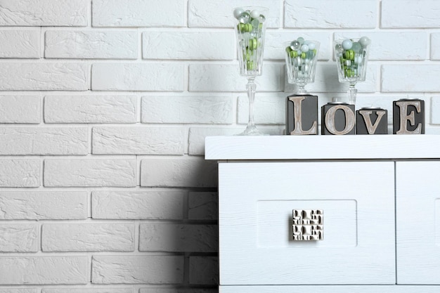 Decorative glasses with word Love on brick wall background