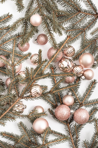 Decorative gold balls and sprigs of spruce on a white background. Top view, flat lay.