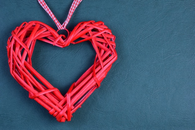 On a decorative green corrugated background on the left side there is a decorative large red heart. On the right there is a place for the inscription on the Valentine's Day