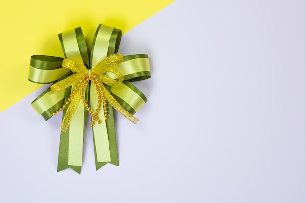 Decorative green ribbon bow on sweet pastel 