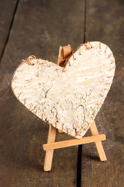 Cuore decorativo su cavalletto, su fondo in legno