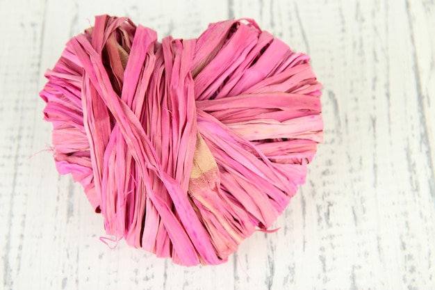 Decorative heart of straw, on wooden background