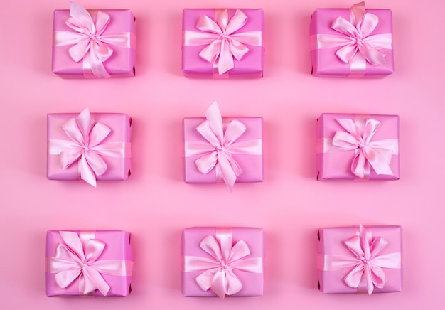 Decorative holiday gift boxes with pink color on pink background.