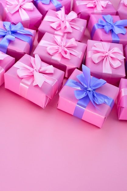 Decorative holiday gift boxes with pink color on pink background.