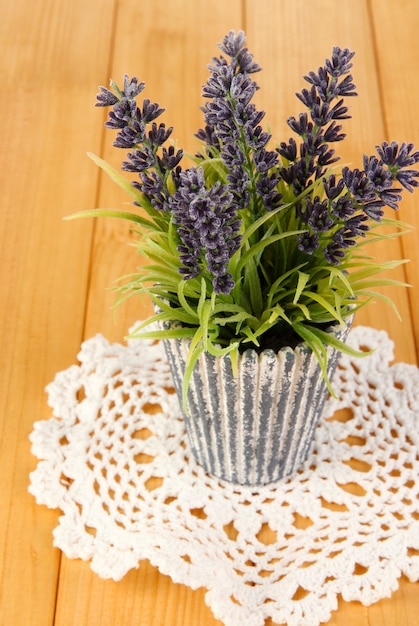 Decorative lavender in vase on wooden table close-up