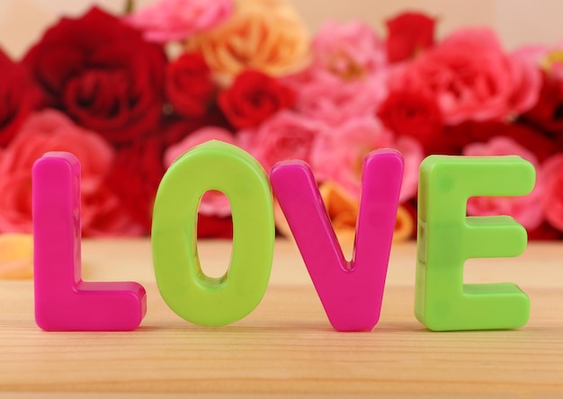 Decorative letters forming word LOVE with flowers on bright background