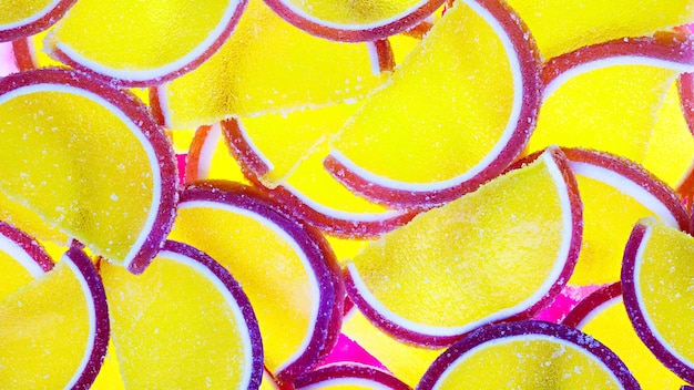 Decorative marmalade candy Background Pattern of marmalade in shape of citrus fruits wedges Jelly sweet candies Food Texture Beautiful Wide Angle Wallpaper or Web banner Top view Flat lay