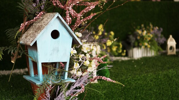 Decorative nesting boxes on bright background. Blue birdhouse on green background. Spring decorations for children or a photo session