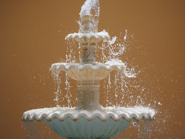 Декоративный старый фонтан со льющейся водой