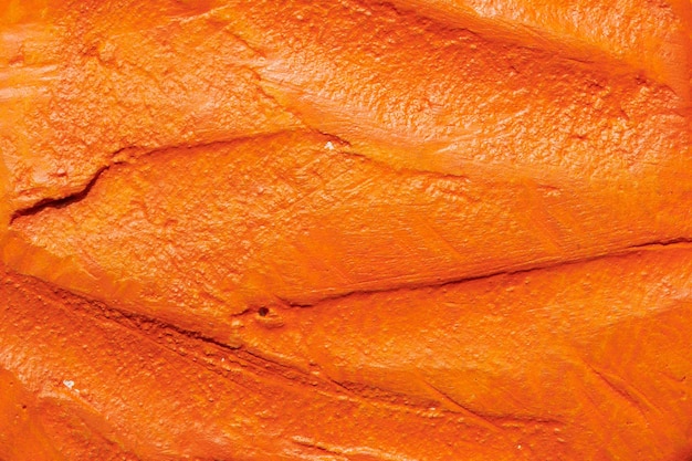 장식용 오렌지 퍼티 배경 주걱으로 적용된 필러 페이스트가 있는 벽 텍스처