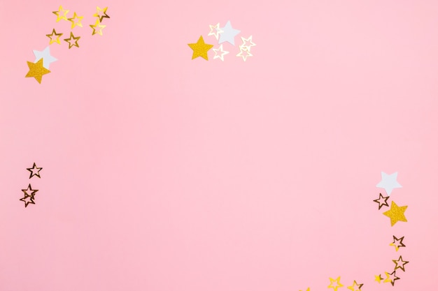 Photo decorative ornaments in the form of stars lie on a pastel pink