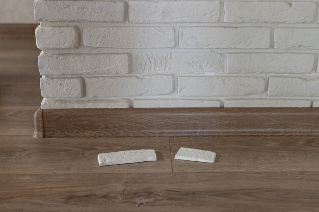 Decorative plaster brick peeled off from the inner wall of the\
house and crashed damaged wall horizontal