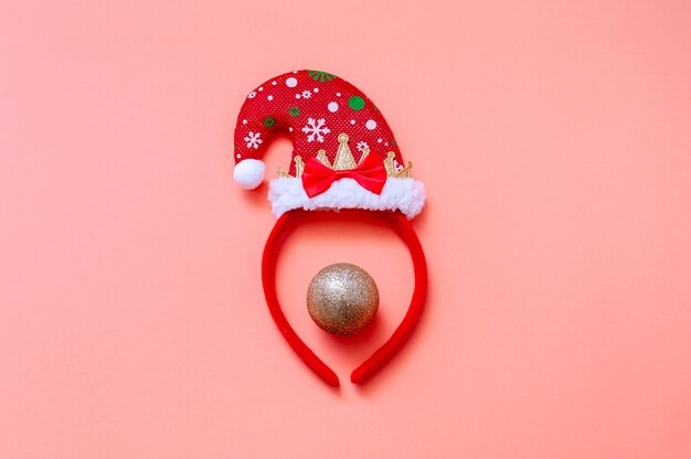 Decorative Portrait with Santa Hat and Christmas Ball. Creative Minimal Christmas Concept.