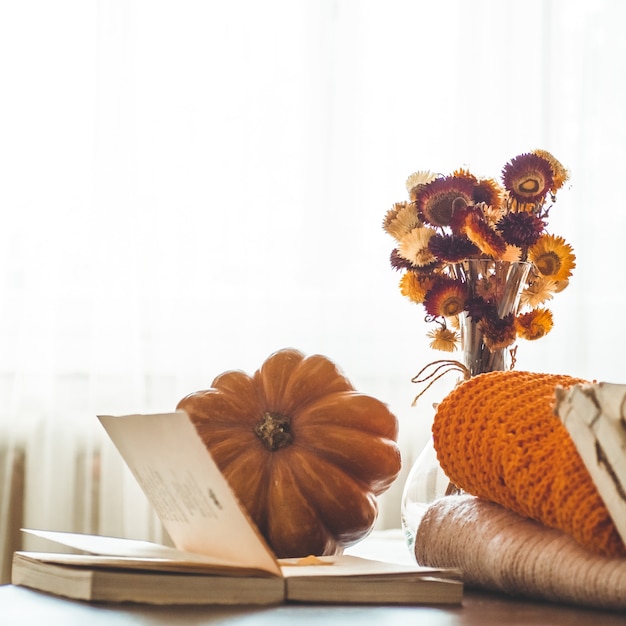 Photo decorative pumpkin, dried flowers, books, warm sweaters. reading in the autumn day. autumn books. autumn reading. cozy  mood.