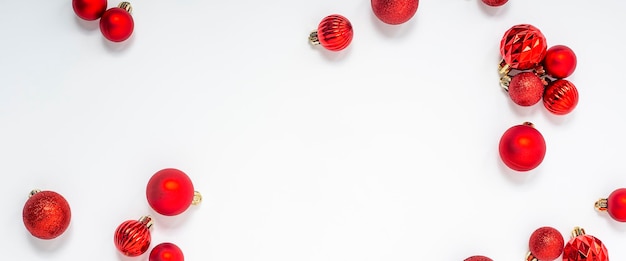 Decorative red balls on a white background. Top view, flat lay. Banner.