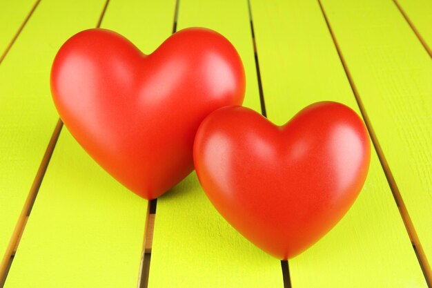 Decorative red hearts on color wooden background