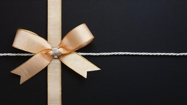 Decorative ribbon bow and silver string on black background