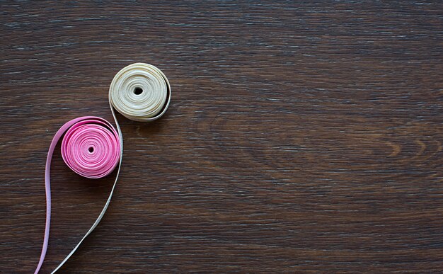 Decorative satin ribbon on dark wooden background