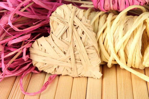 Decorative straw for hand made and heart of straw, on wooden background