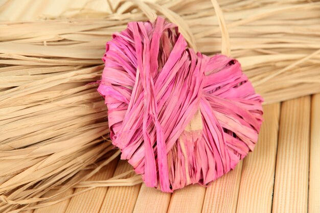 Decorative straw for hand made and heart of straw, on wooden background