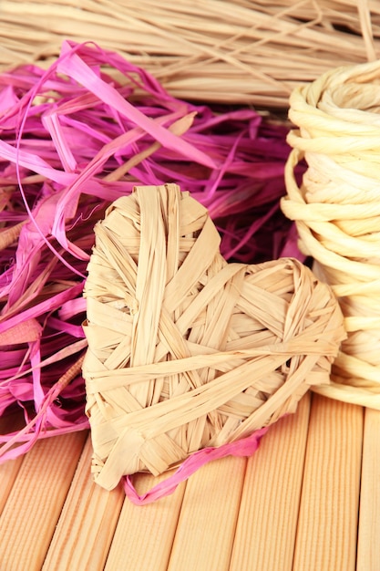 Decorative straw for hand made and heart of straw, on wooden background