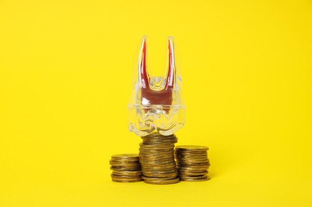 Decorative tooth and coins on yellow background