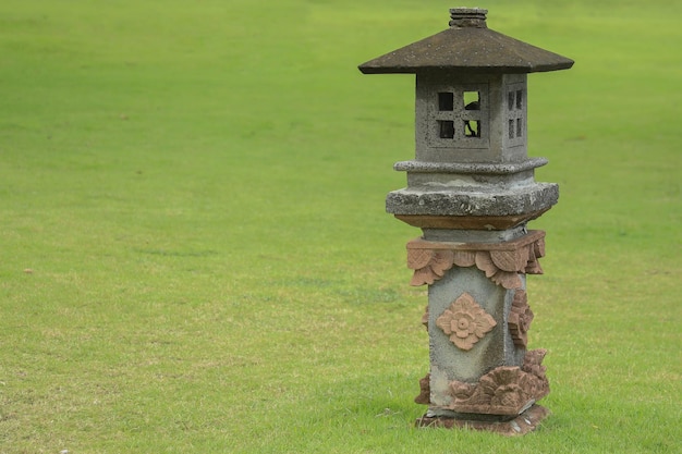 Decorative traditonal lamp from stones lantern in green grass Garden design