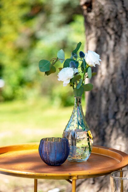 Decorative vases with fresh outdoor flowers, wedding decor. Soft selective focus.