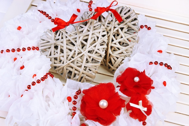 Decorative wreath with wicker hearts on wooden background