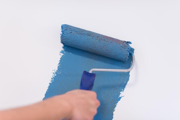 Decorator's hand painting wall with roller