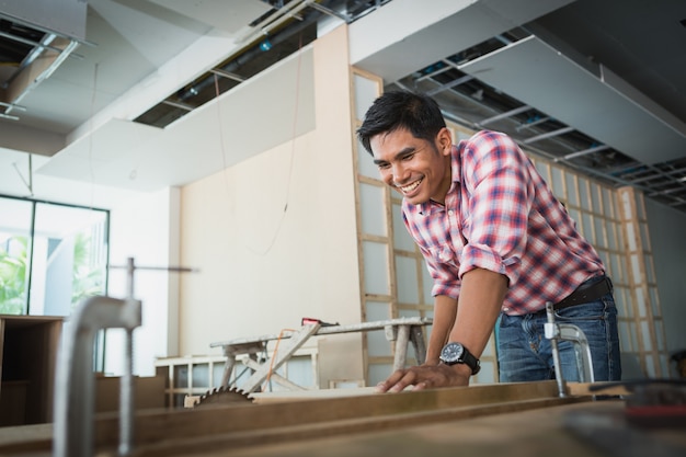 Decorator working on design and inspect of plywood at construction site; decorator checking material for interior